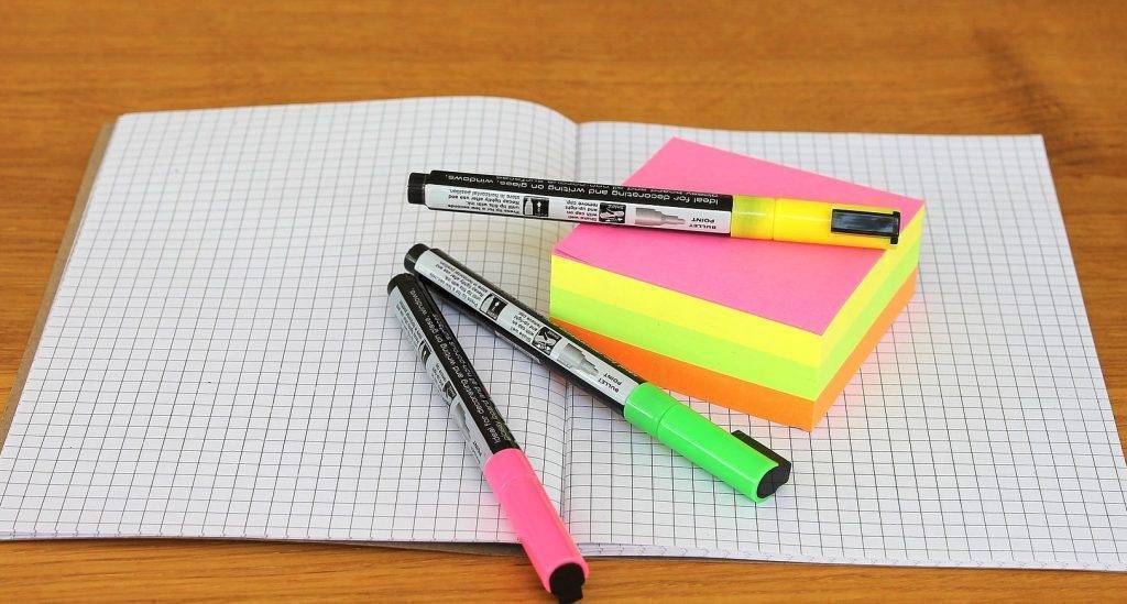 Graph paperm highlighers, and post-its on a desk