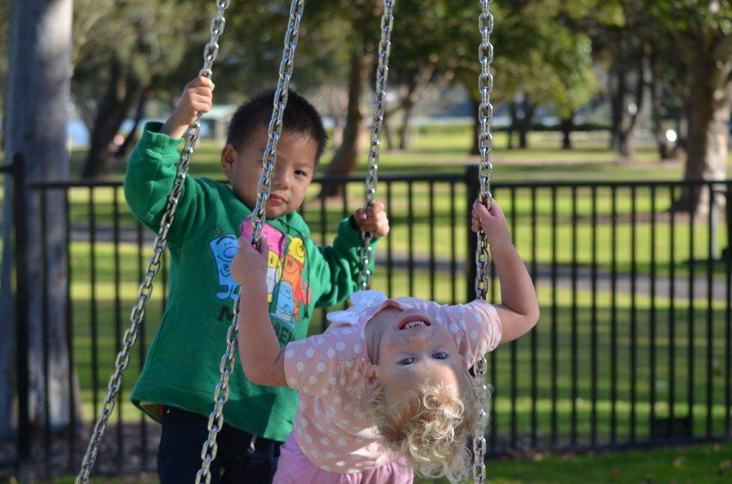 two children swinging on a tire swing