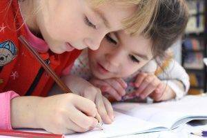 two students reading and making notes in a book