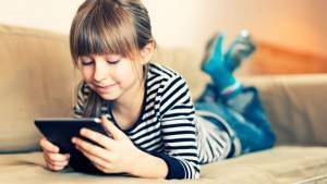 Girl looking at tablet on couch