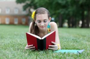 girl reading book in the grass