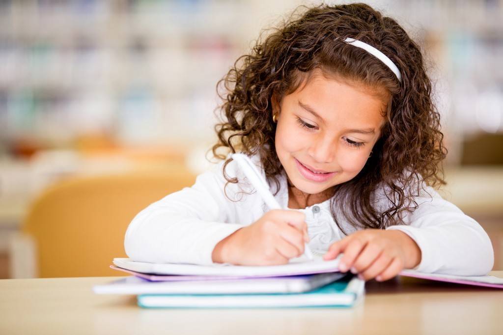 happy-girl-writing-1024×682 Girl writing in notebook at a desk