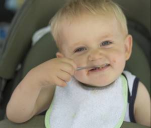 Baby eating food off of a spoon