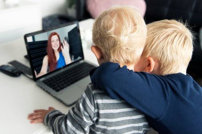 two children watching educational video on laptop