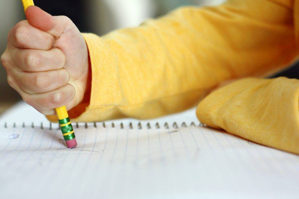 student erasing notes on notebook