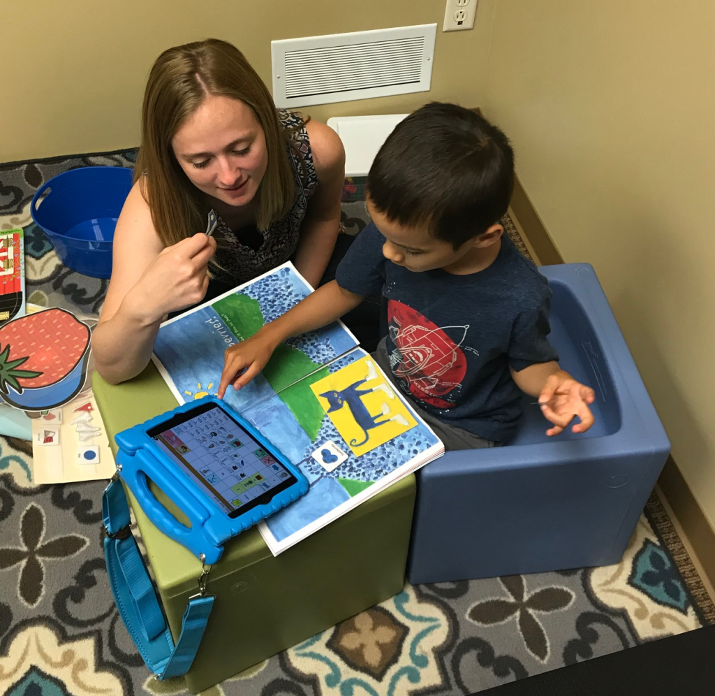 student and teacher working on tablet and reading a book