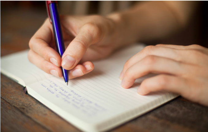 Student writing in notebook