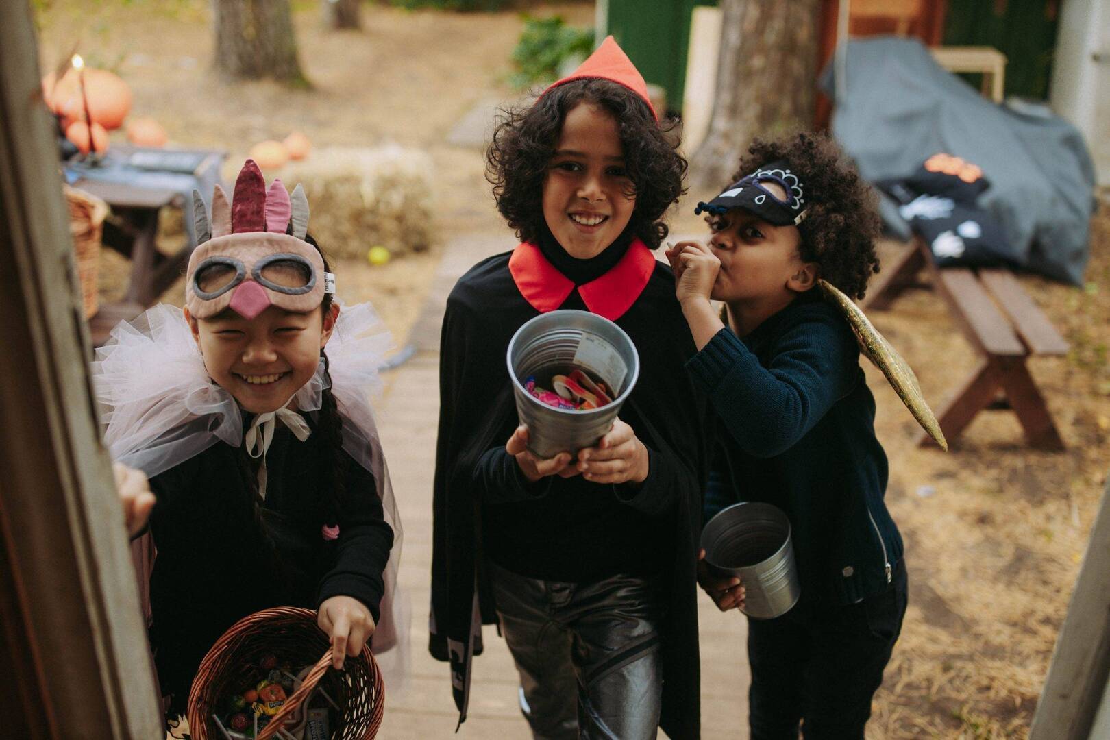 three children in costumes trick-or-treating