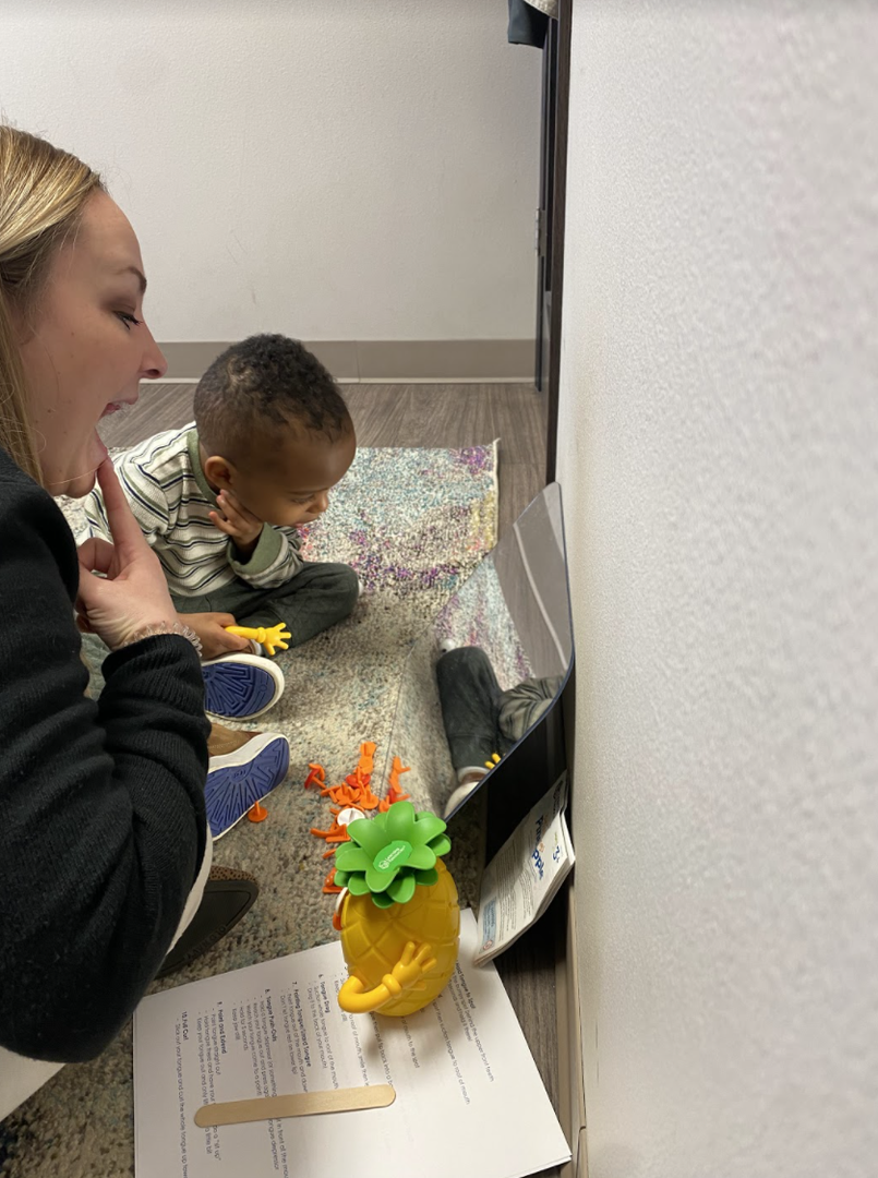Speech pathologist with child working on tongue tie
