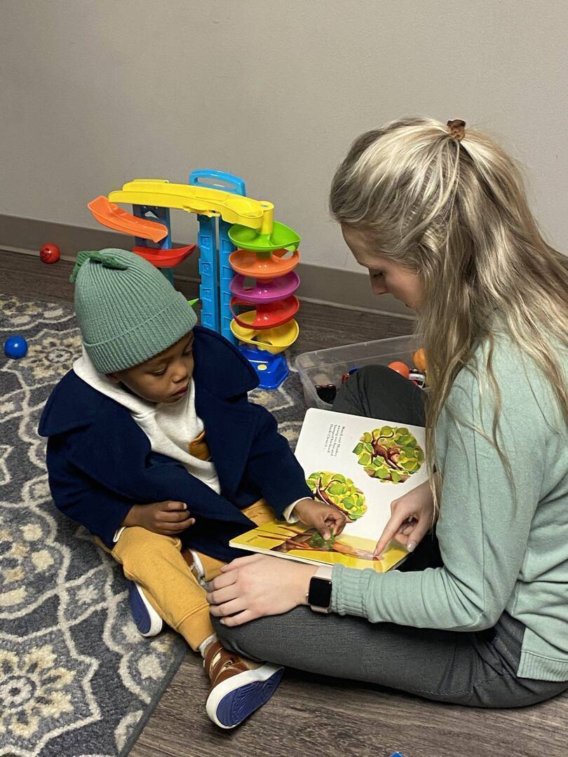 Student and teacher reading a book