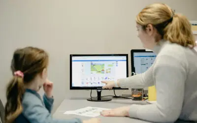 Student and teacher looking at computer monitor