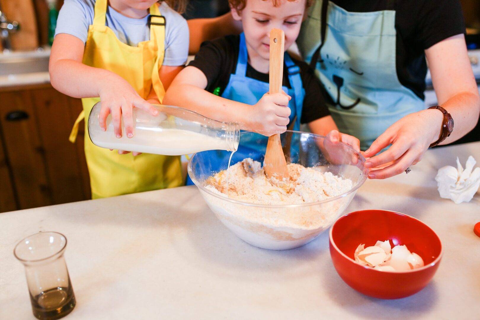 Adult helping two with recipe