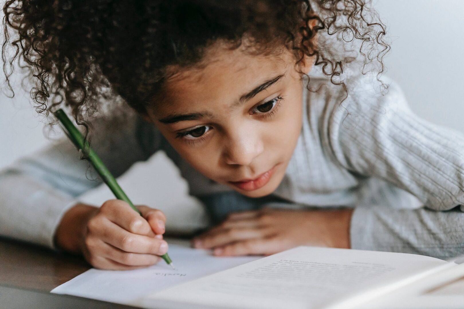 WritingOption1 child writing and looking at workbook