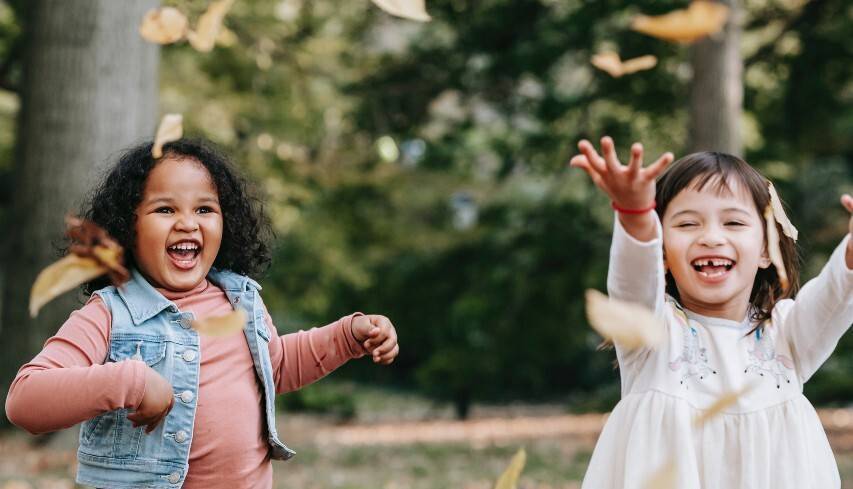 Two children playing the leaves