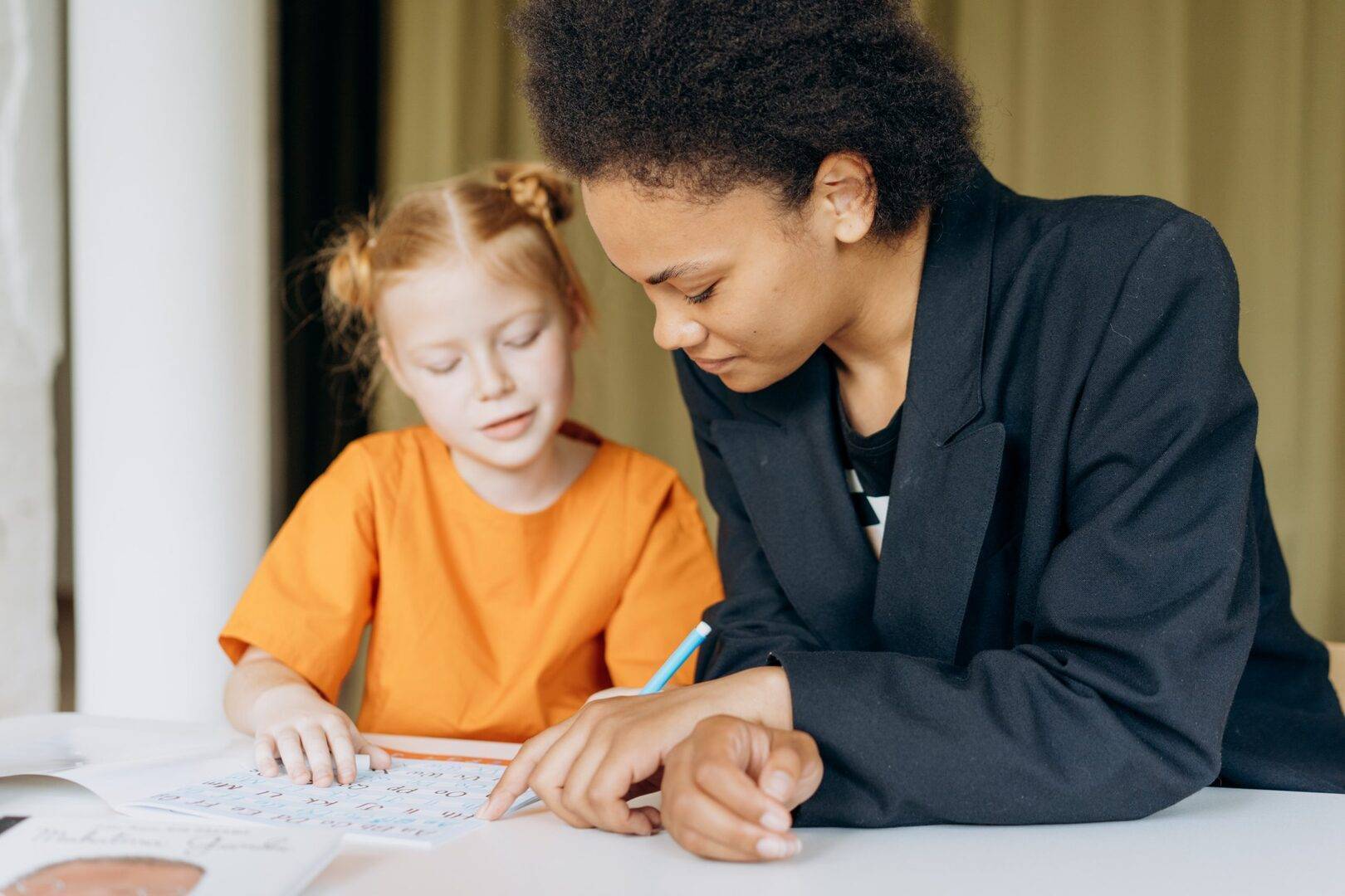 Adult helping child with letter practice