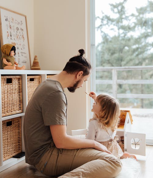 Dad and daughter playing with toy house