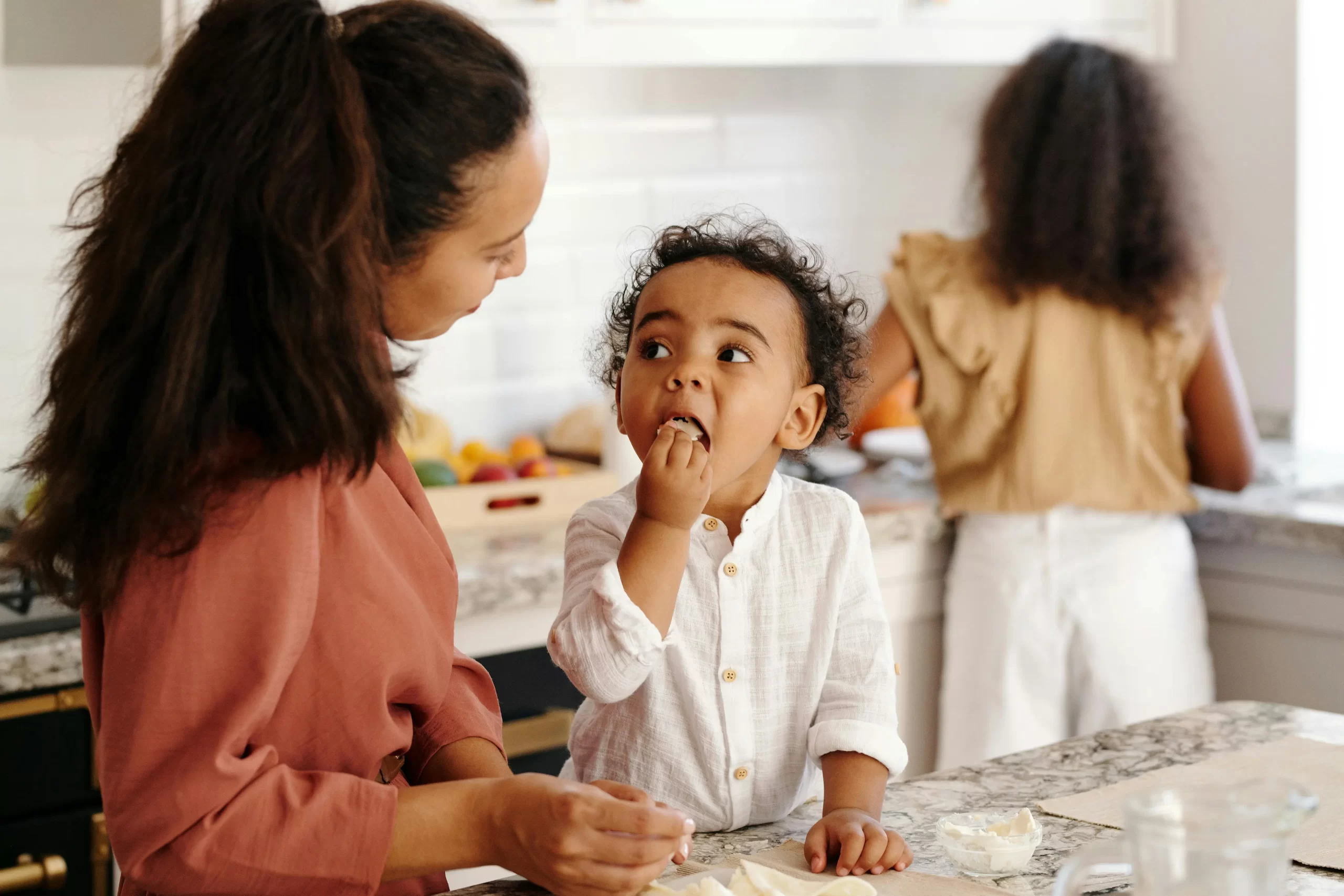 pexels-vanessa-loring-5082625 toddler standing at kitchen island and eating.