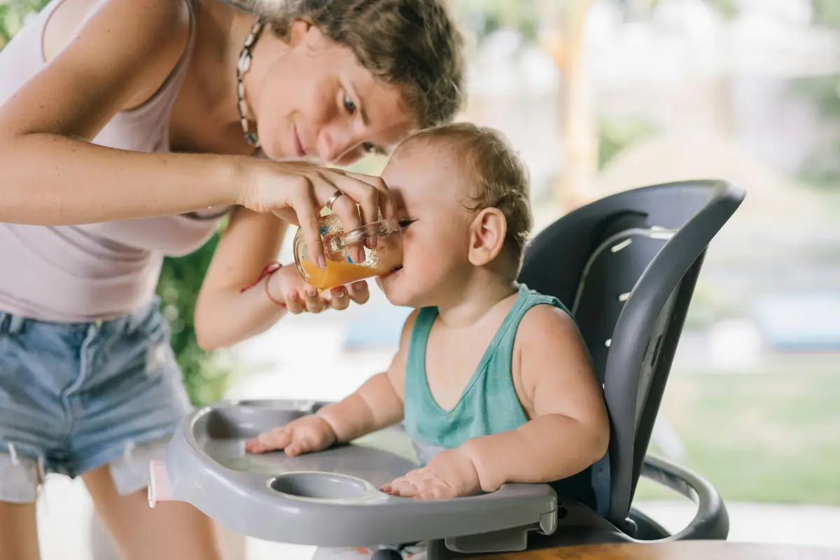woman holds cup up to baby's mouth