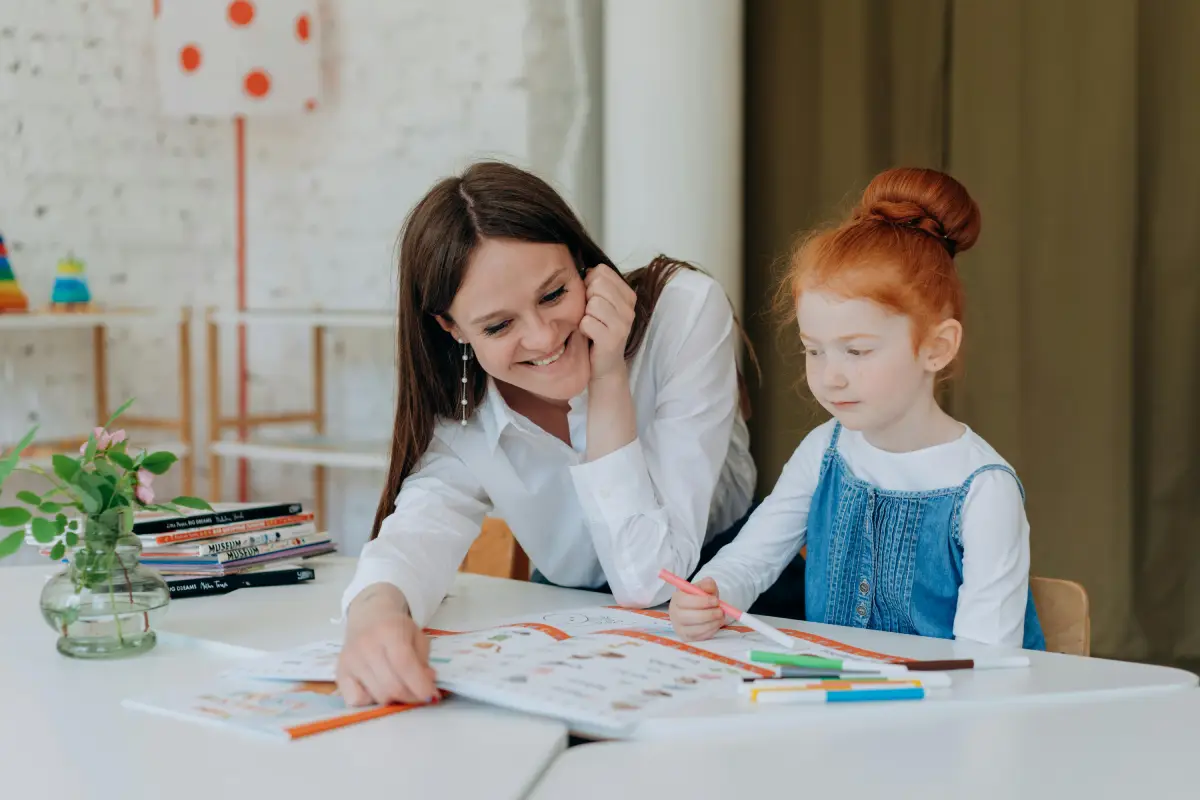 Creating a schedule woman helps young girl with mapping out a visual schedule