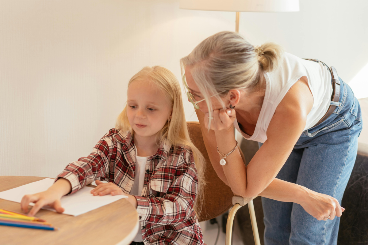 mom and daughter mother helps daughter with math at table