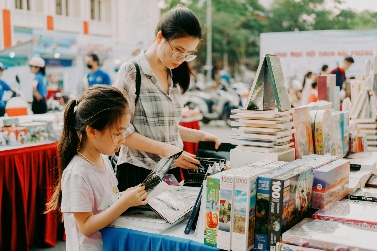 mother and daughter stand outside at a book sale