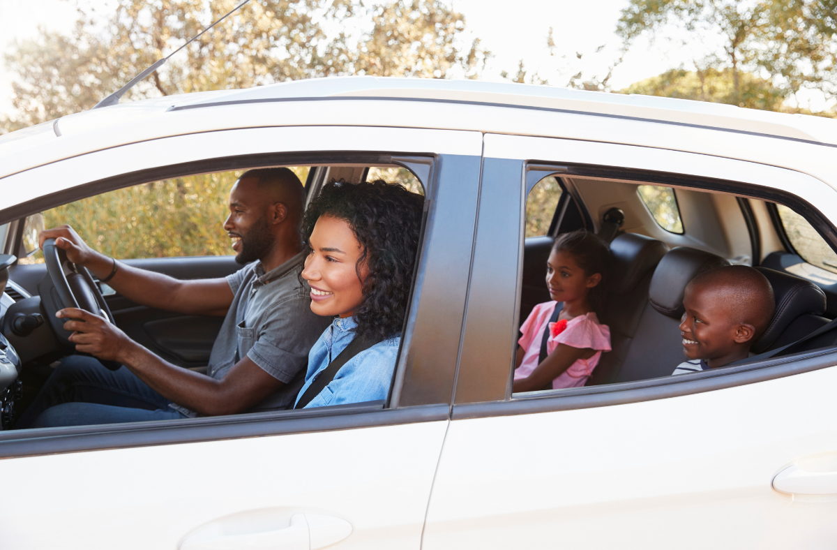 Family in Car family sits in a car together, smiling