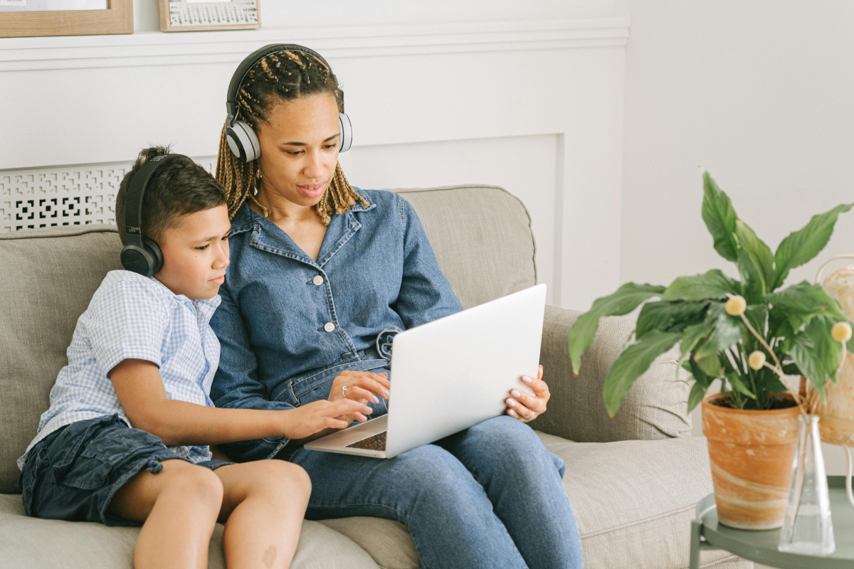mother and son sit on couch to study together