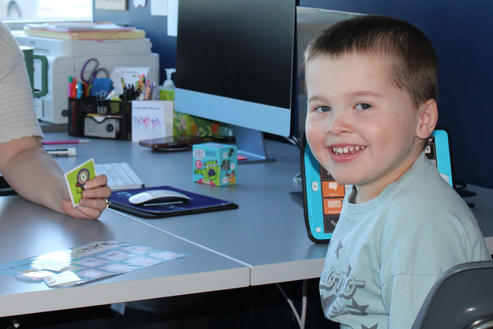 is-my-child-ready-for-preschool-or-kindergarten Smiling preschooler at a desk with picture cards during a school readiness screening at ETLC