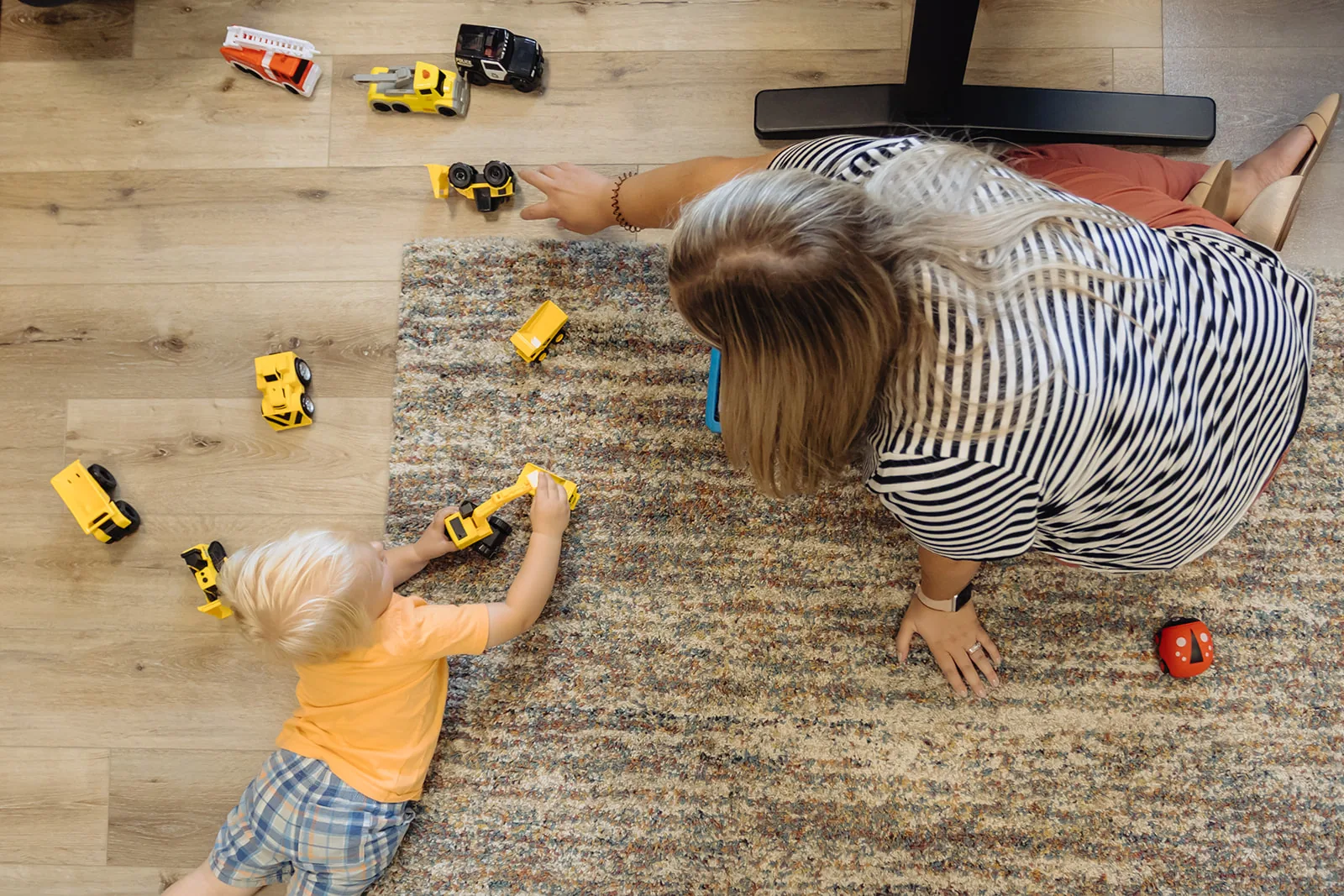 what-is-floortime-and-how-can-it-help-my-child Adult lying on the floor playing with toy cars alongside a toddler during a Floortime session