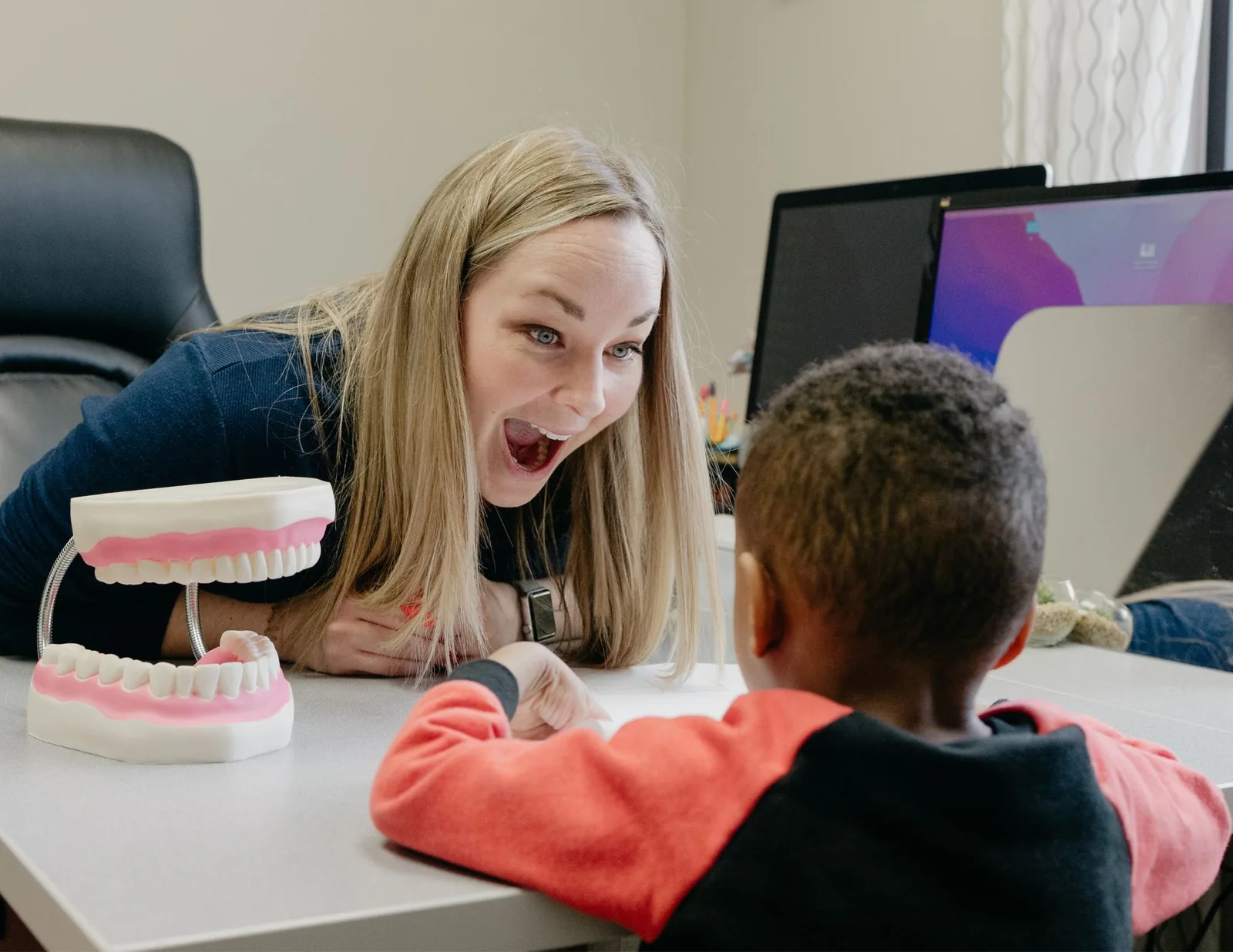what-is-tongue-tie-and-when-should-it-be-treated ETLC therapist using an oral anatomy model to demonstrate tongue placement to a child